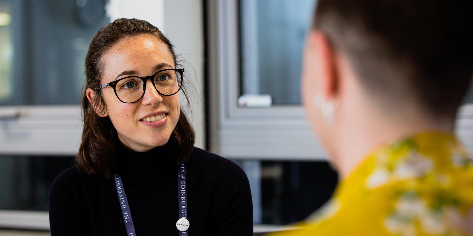 A staff member listens to a student